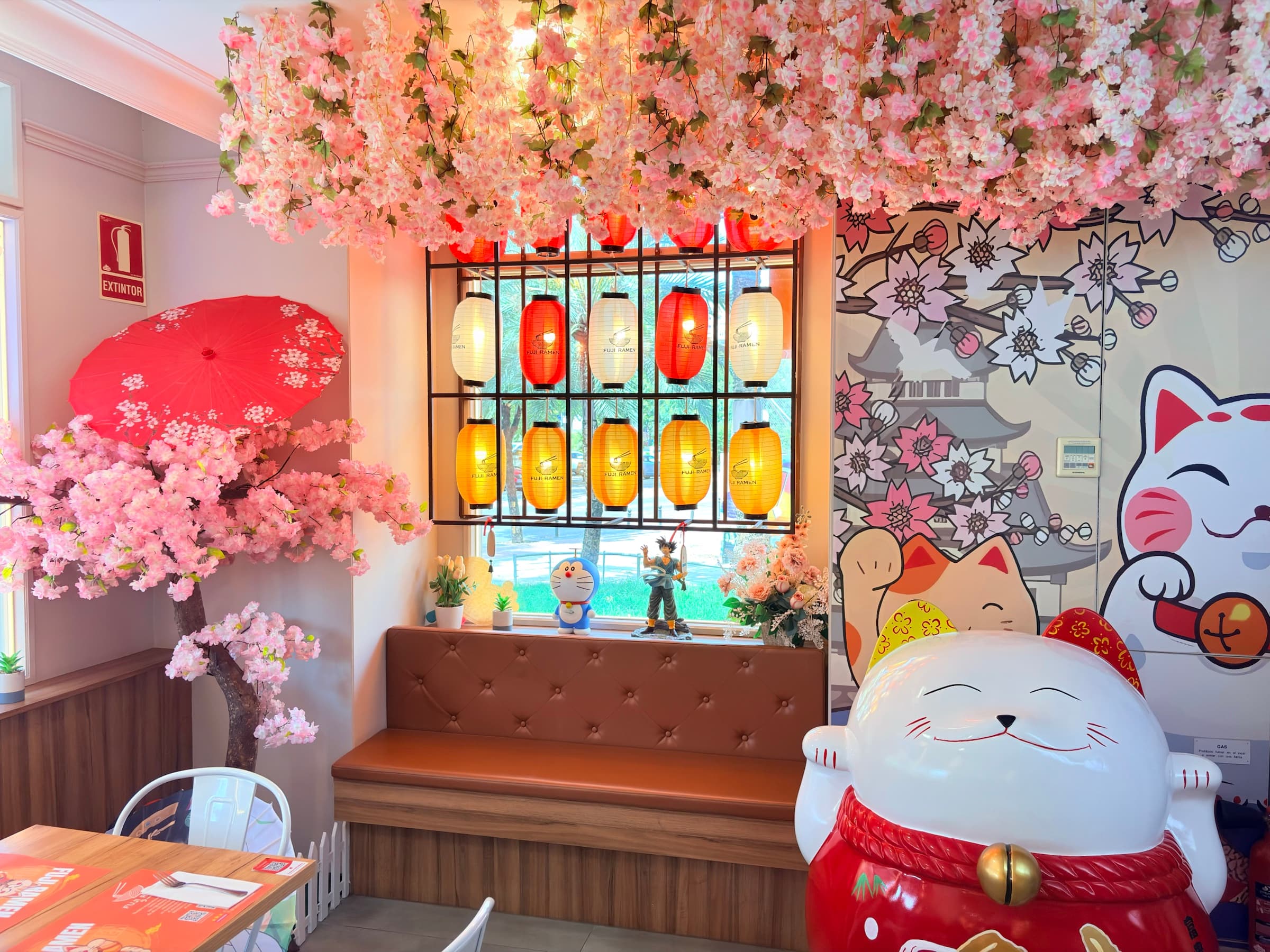 Interior de Fuji Ramen con farolillos, flores de cerezo y un gato de la suerte